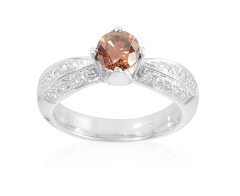 A 0.85 CARAT FANCY BROWN DIAMOND AND WHITE DIAMOND RING in 18ct white gold set with a round cut brown diamond of 0.85 carats 