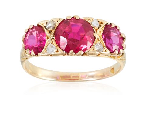 AN EDWARDIAN THREE RED STONE AND DIAMOND RING, in 18ct yellow gold, set with three round cut red stones and diamond chips, wi