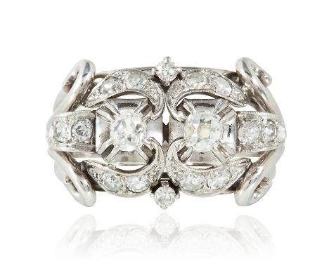 AN ART DECO DIAMOND RING in platinum and 18ct white gold set with two round cut diamonds within scrolling motifs further jewe