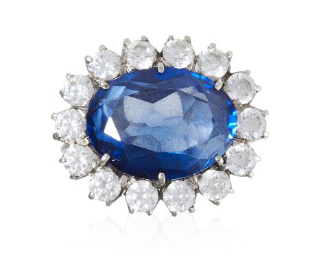 A SAPPHIRE AND DIAMOND CLUSTER RING in white gold or platinum, set with a synthetic sapphire, in round cut diamonds totalling