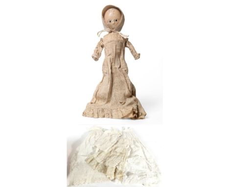 A Late 18th/Early 19th Century Wooden Doll, with large almond shaped eyes, stitched eyebrows and eyelashes, rouged cheeks, on