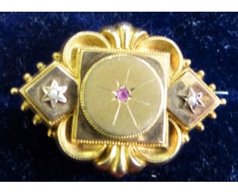 A Victorian 9ct gold target brooch Birmingham 1893, set with a ruby and flanked by 1/2 pearls, locket back, case