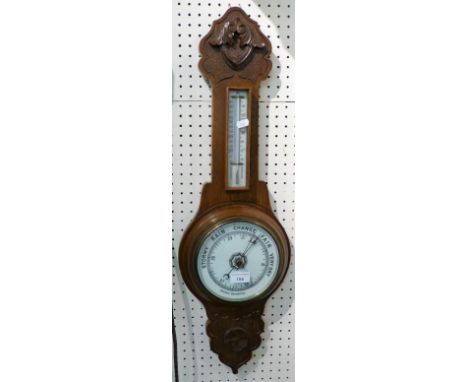 A carved walnut cased combined aneroid barometer and thermometer.