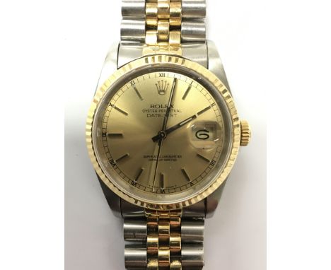 A gents Rolex oyster perpetual Datejust chronometer wristwatch. The gold tone dial presents both baton and Roman numerals and