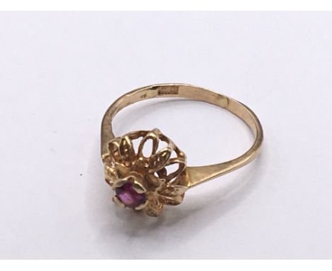 An Indian or foreign high grade gold ring set with a small ruby weight 2g ring size M.