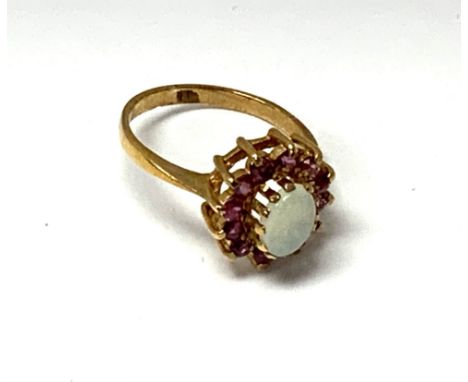 A 9ct gold ring set with pink sapphires and a central oval polished opal, Size L, (Cat A).