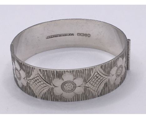 A wide patterned silver bangle with Sheffield hallmarks for 1977. Weight 43g