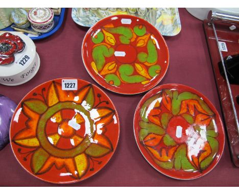 Poole Pottery - Two Plates in the Aegean Manner, with green and yellow decoration on red ground, 20.5cm diameter, black backs