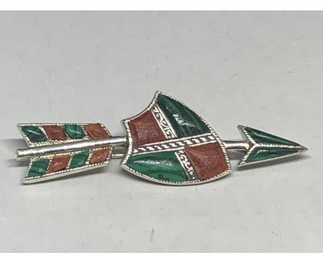 A GREEN AND RED STONE BROOCH DEPICTING A SHIELD AND ARROW 