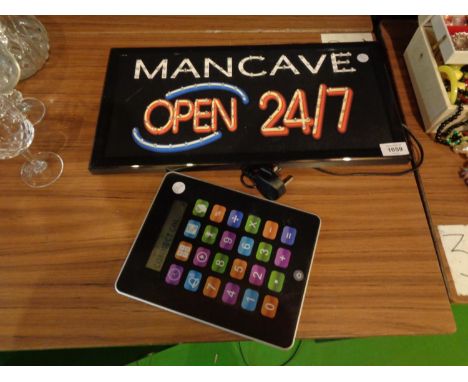 A LIGHT UP MAN CAVE WALL SIGN AND A LARGE DIGITAL CALCULATOR 