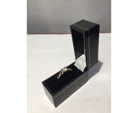 A 9 CARAT GOLD RING WITH A CLEAR STONE SOLITAIRE AND A TWISTED DESIGN ON THE SHOULDER IN A PRESENTATION BOX 