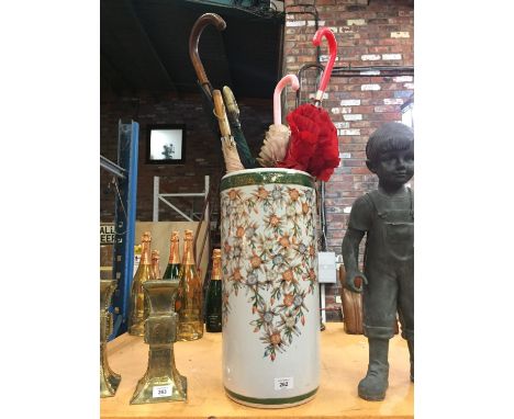 A DECORATIVE CERAMIC UMBRELLA STAND WITH SIX VINTAGE UMBRELLAS 