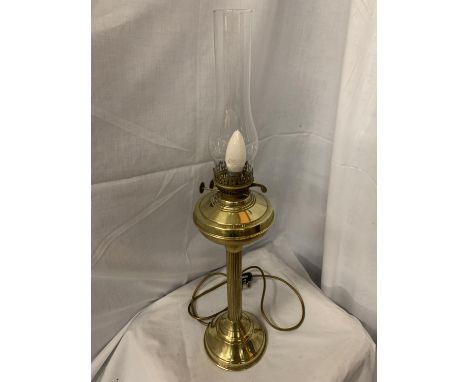 A BRASS COLUMN OIL LAMP WITH GLASS CHIMNEY H:47CM INC. CHIMNEY 69CM (BEEN CONVERTED TO ELECTRIC) 