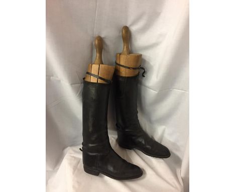A PAIR OF LEATHER RIDING BOOTS WITH VINTAGE WOODEN BOOT SUPPORTS 