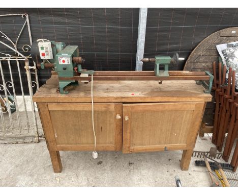 A WOOD TURNING LATHE ON A WOODEN WORK BENCH 