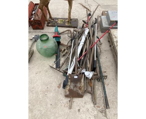 A LARGE ASSORTMENT OF GARDEN TOOLS TO INCLUDE SHOVELS, RAKES AND A LARGE GLASS VASE 