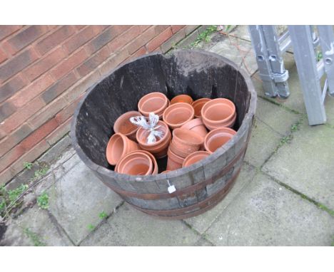 AN OAK HALF BARREL PLANTER 76cm in diameter containing a quantity of old and new terracotta pots (25)