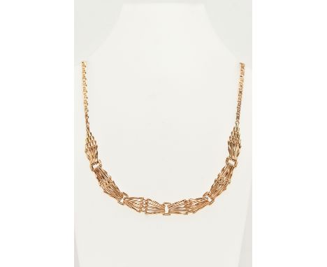 A 9CT GOLD ITALIAN NECKLACE, designed as a gate necklace leading on to a fancy curb link chain, fitted with a lobster clasp, 