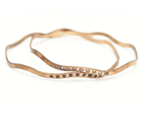 A PAIR OF MATCHING SILVER BANGLES, wave design bangles, one set with nine star set blue spinel's, the second set with seven s