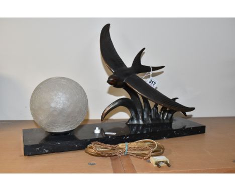 A FRENCH ART DECO TABLE LAMP, with bronzed bird in flight figure, beside a textured frosted glass shade, surmounting a grey m