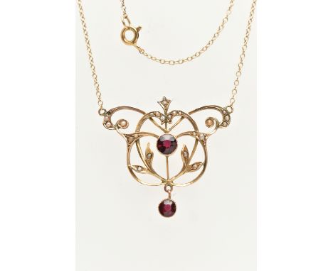 AN EDWARDIAN YELLOW METAL LAVALIER PENDANT NECKLACE, open work floral design set with a central circular cut garnet, and circ