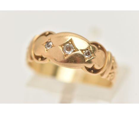 A YELLOW METAL DIAMOND RING, set with three small old cut diamonds, to the scrolling shoulders and polished band, stamped 18c