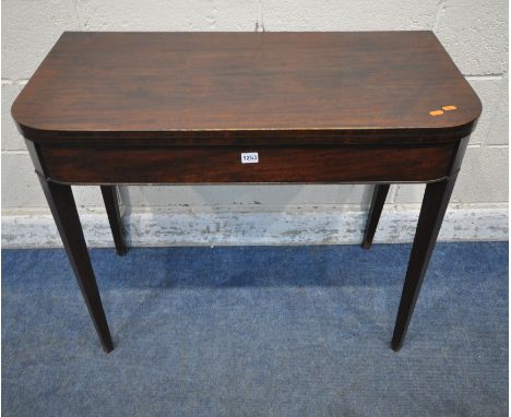 A GEORGIAN MAHOGANY CARD TABLE, the fold over top enclosing a green baize playing field, raised on square tapered legs, width