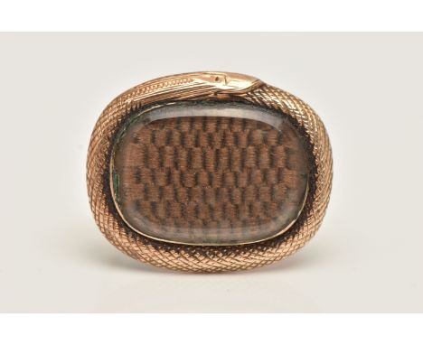 AN EARLY TO MID VICTORIAN ROSE METAL OUROBOROS MOURNING BROOCH, of rounded oval form with textured snake surround, inlayed wi