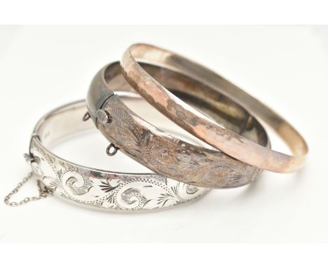 THREE BANGLES, to include two silver hinged bangles, both with foliate patterns, push piece clasps and one fitted with an add