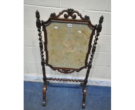 A VICTORIAN MAHOGANY FIRESCREEN, with foliate and scrolled details, barley twist supports and stretcher, raised on shaped leg