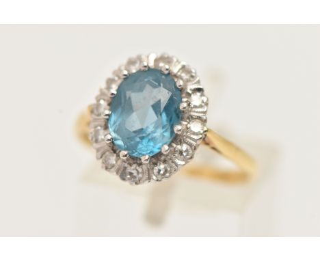 AN 18CT GOLD TOPAZ AND DIAMOND CLUSTER RING, the oval blue topaz within a single cut diamond surround, 18ct hallmark for Birm