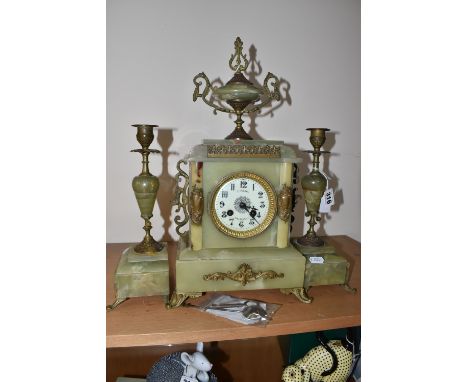 A FRENCH GREEN ONYX CLOCK GARNITURE, the garniture in the form of candlesticks, the clock case surmounted by an urn style fin