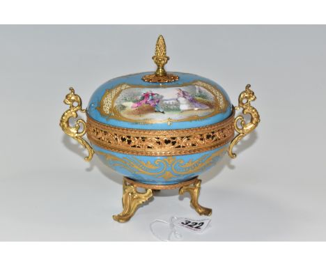 A GILT METAL AND PORCELAIN BOWL AND COVER, the cover bearing gilt pineapple finial and painted with vignettes of a couple and