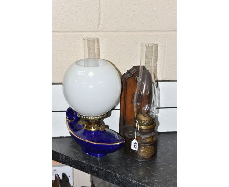 TWO OIL LAMPS comprising a Duplex cobalt blue ceramic and glass oil lamp in the form of an eastern lamp, height 40cm, and a m