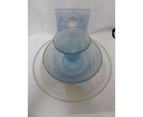 A Group of Art Deco blue glass wares, including a clock case, decorated with two semi clad women flanking the aperture; a bow