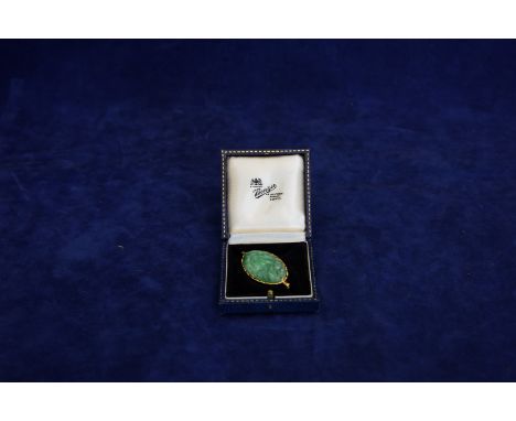 An oriental oval jade brooch in a gold coloured metal frame.  Est £40-60