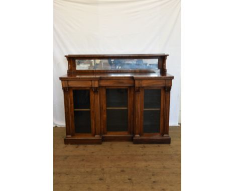 A Victorian rosewood chiffonier with shelf to the top section and mirrored back above a recessed central glazed cupboard flan