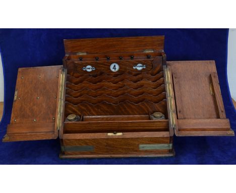 A Victorian oak and brass bound desk top stationary box, the two doors opening to reveal a pigeon holed interior with day, da