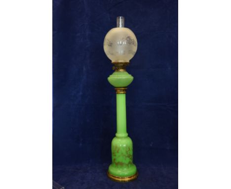 A green opaline glass oil lamp with frosted white glass shade, green glass reservoir and green glass central column with gilt