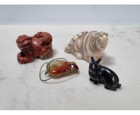 A carved black stone figure of a rabbit, a stone figure of seated Tiger, a carved red stone figure of Griffin 2in, slight dam
