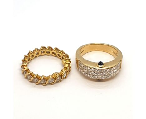 A half-hoop Diamond Dress Ring set three rows of princess-cut stones and a cabochon sapphire to the profile of the setting, r