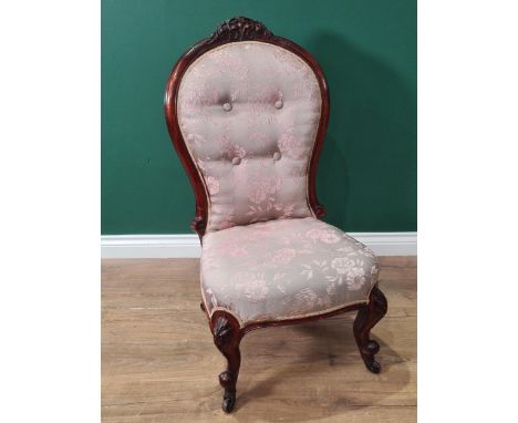 A Victorian Nursing Chair with pink and grey floral button upholstered back on cabriole front legs and casters