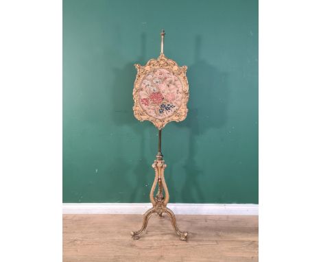 An early Victorian elaborately gilt Polescreen with floral tapestry panel, the pierced and shaped column on tripod base, 5ft 