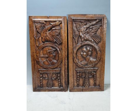A pair of 16/17th century carved oak Portrait Panels with man and woman surmounted by bird, 17 x 8in
