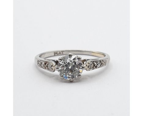 A Diamond Ring, claw-set old-cut diamond in a rex collet with split tapered shoulders set small diamonds in white metal stamp