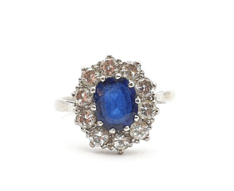 A mid-century Sapphire and Diamond Cluster ring, claw-set oval mixed-cut sapphire, surrounded by ten pavé-set brilliant-cut d