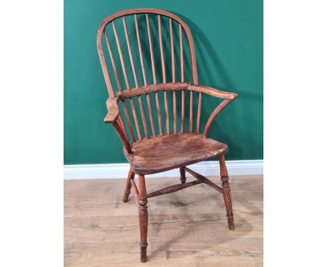 A 19th century stick back Windsor Elbow Chair with solid seat on turned legs united by H stretcher