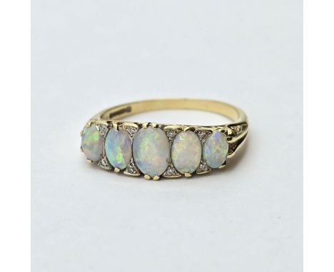 A five stone Opal Ring, claw-set graduated opals interspersed with single-cut diamonds in a scrolled 18ct gold setting, full 