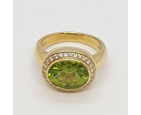 A Peridot and Diamond Dress Ring by Kiki McDonough, rubover-set oval mixed-cut peridot surrounded by pavé-set brilliant-cut d