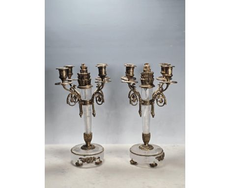 A pair of Ormolu and rock crystal four branch Candelabra with central "flame" finial on tapering rock crystal stems and ormol
